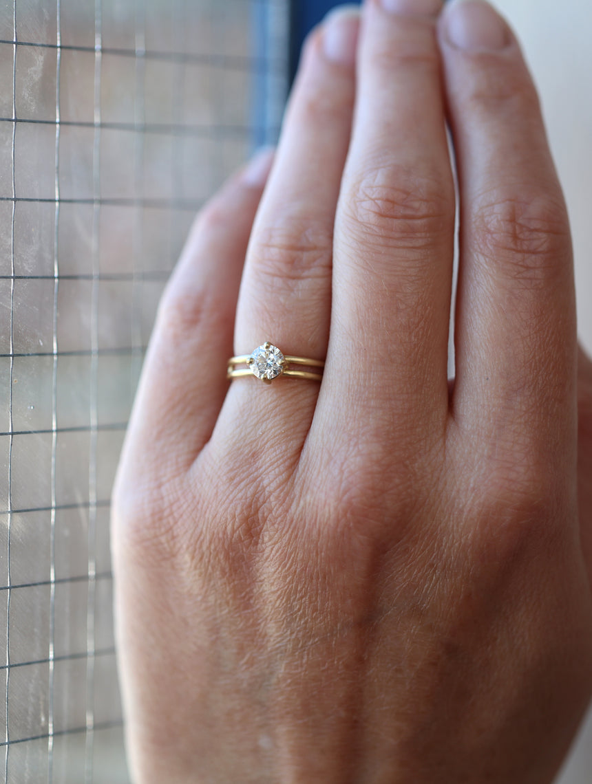 Solitaire ring with round white diamond and double band. 18ct yellow gold, polished finish. On hand.