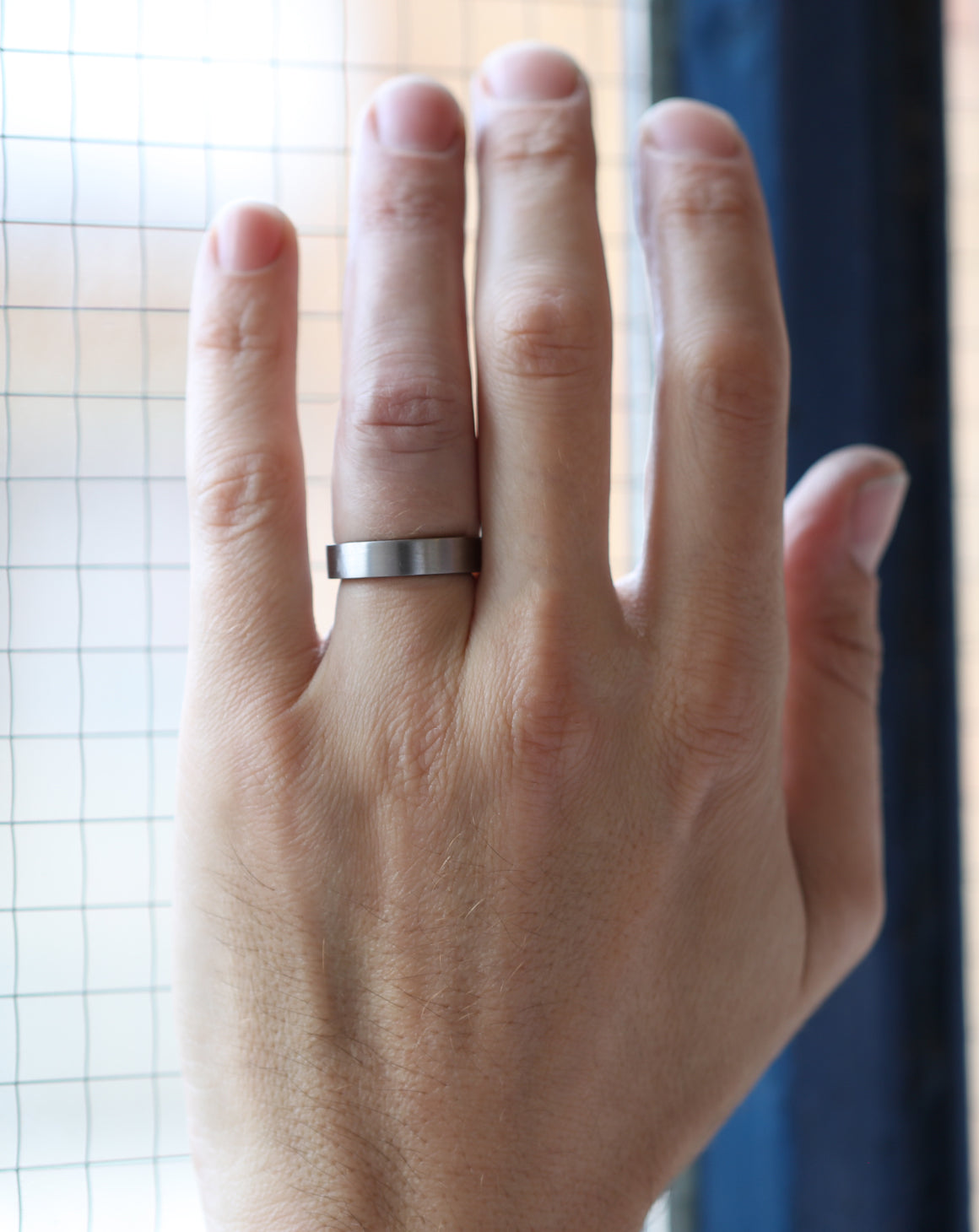 Flat wedding band. 18ct white gold, satin finish. On hand.