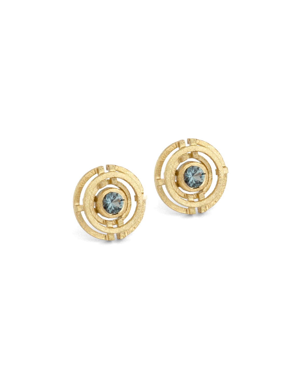 Geometric earrings with concentric circles and central teal sapphires. 18ct yellow gold, textured finish.