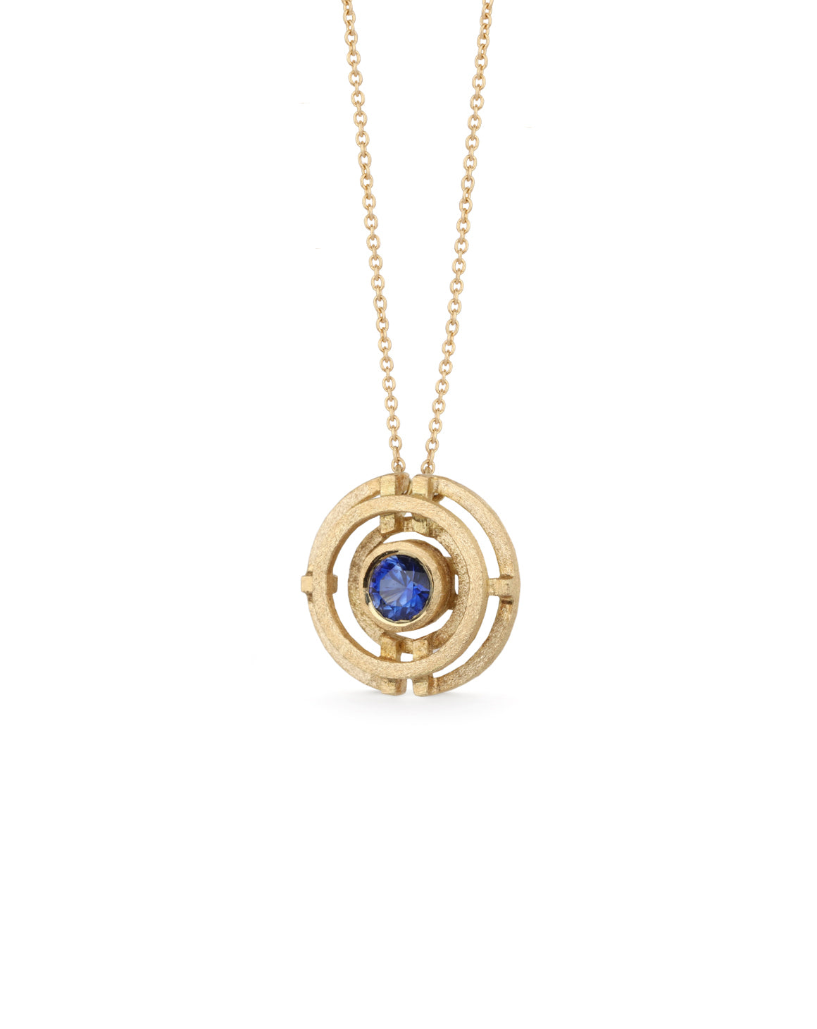 Geometrically patterned pendant featuring a central blue sapphire. Textured 18ct yellow gold. Side view.