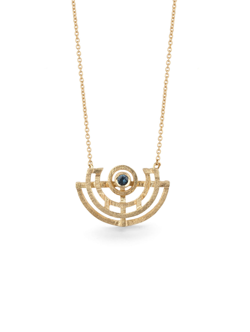 Geometric pendant with semicircular detail and teal sapphire. 18ct yellow gold, textured finish.