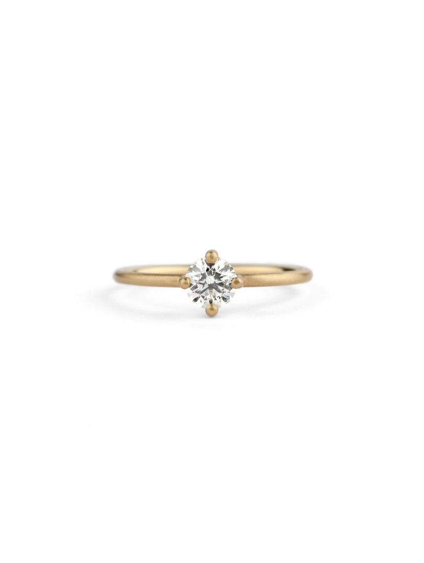 Solitaire ring with round white diamond, four claw setting. 18ct yellow gold, satin finish.