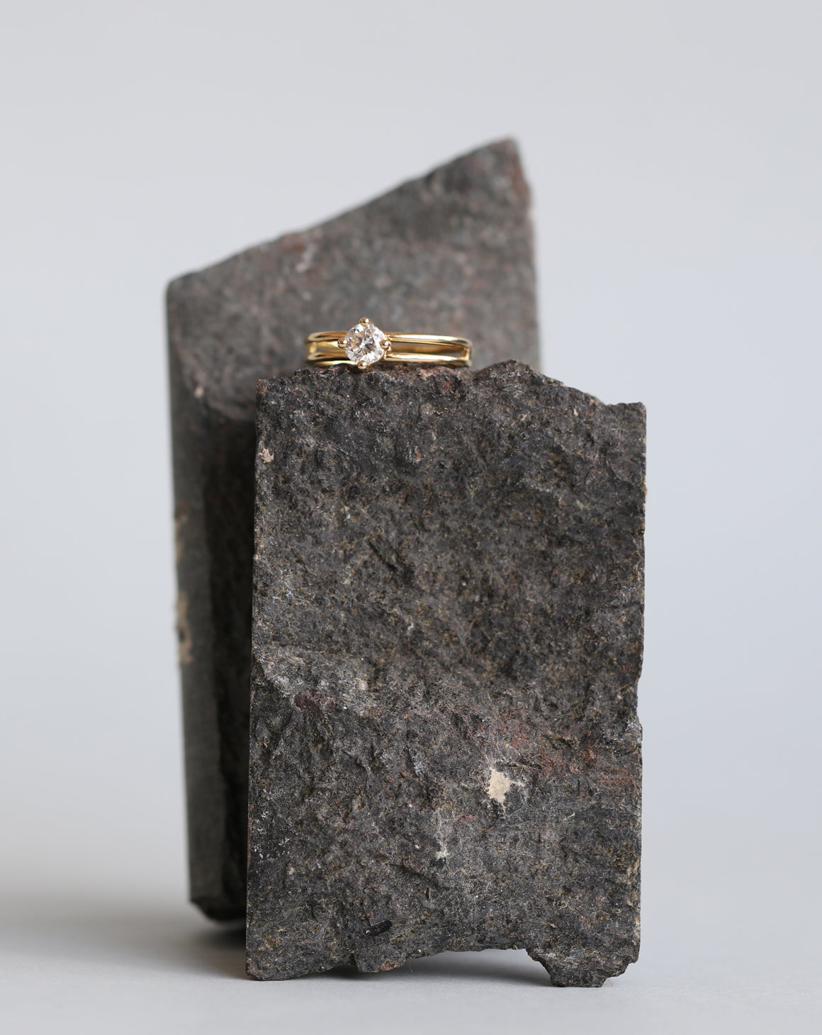 Solitaire ring with round white diamond and double band. 18ct yellow gold, polished finish. On the rock.