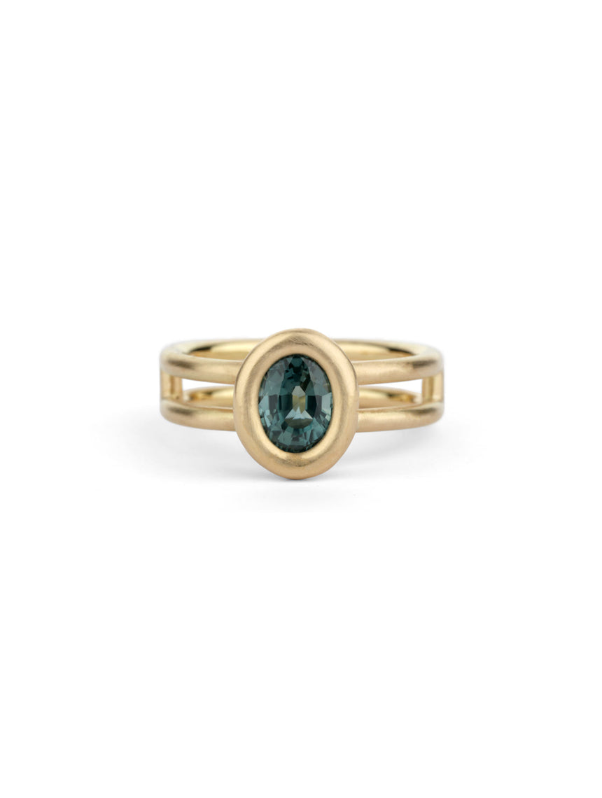Solitaire ring with oval teal sapphire and double band. 18ct yellow gold, satin finish.