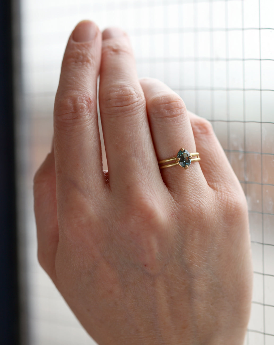 Steely blue oval sapphire ring, on hand.