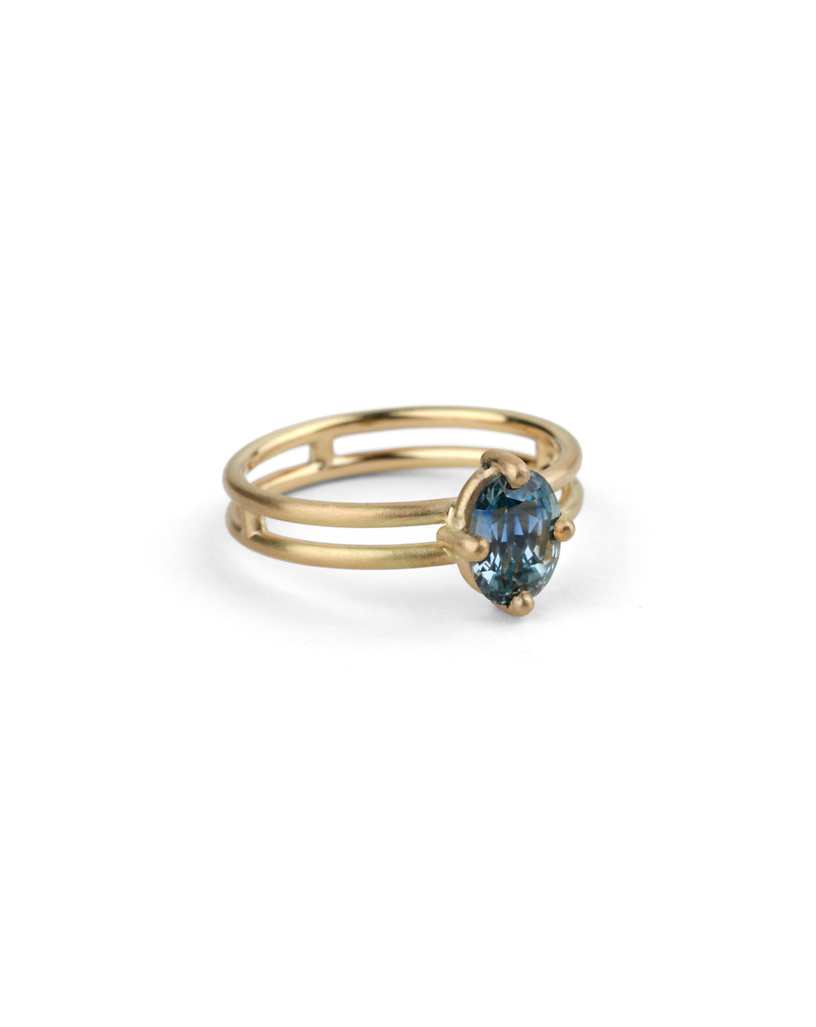 Steely blue oval sapphire ring. Four claw solitaire setting and double band, 18ct yellow gold satin finish, side view.