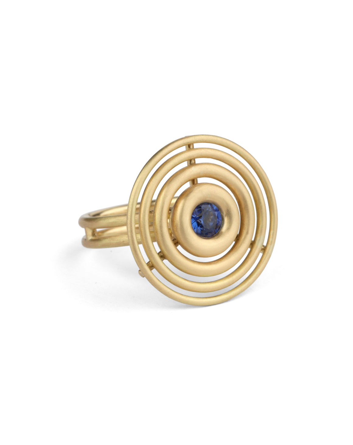 Statement ring made from concentric circles. Central blue sapphire surrounded by 18ct yellow gold rings.