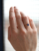 Oval blue sapphire ring, solitaire four claw setting. 18ct yellow gold with a satin finish. On hand.