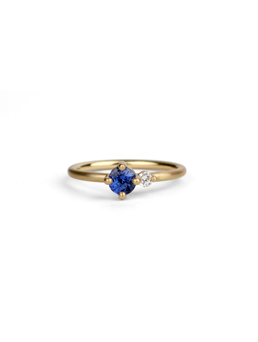 Round vivid blue sapphire ring with a round white diamond. 18ct yellow gold, satin finish.