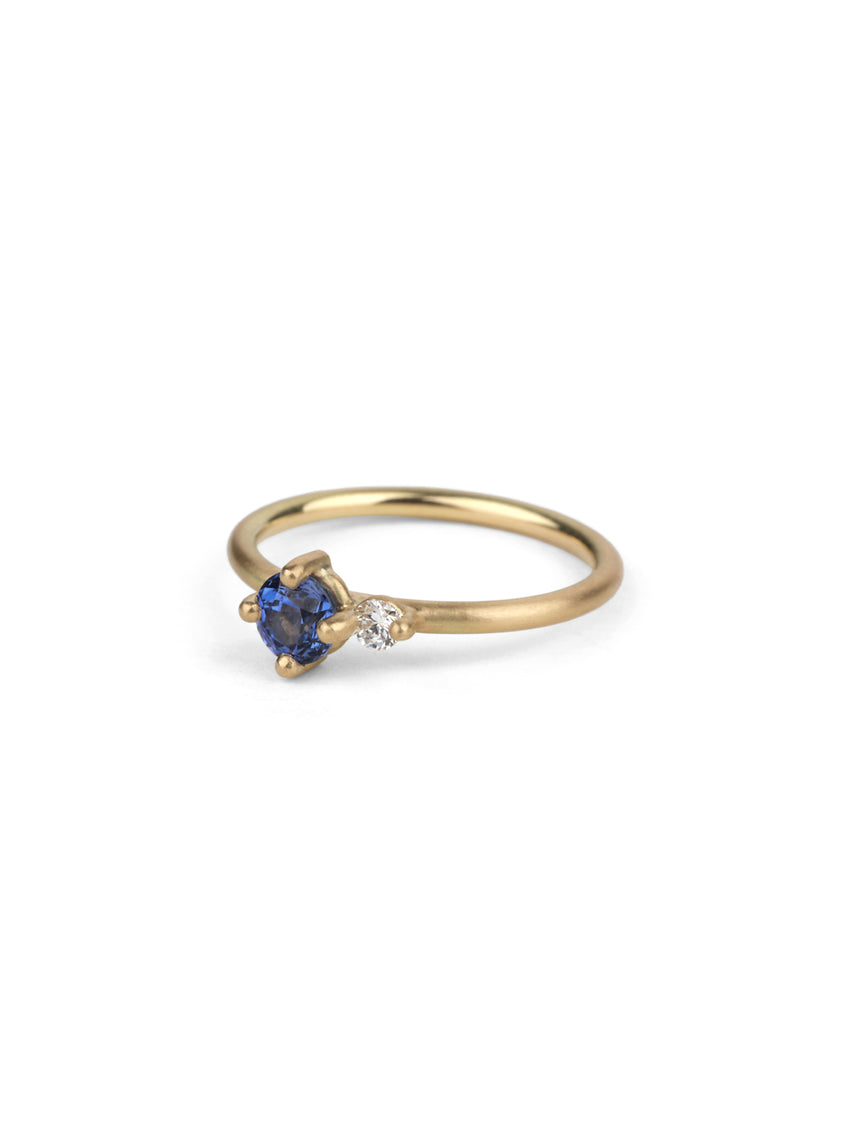 Round vivid blue sapphire ring with a round white diamond. 18ct yellow gold, satin finish.