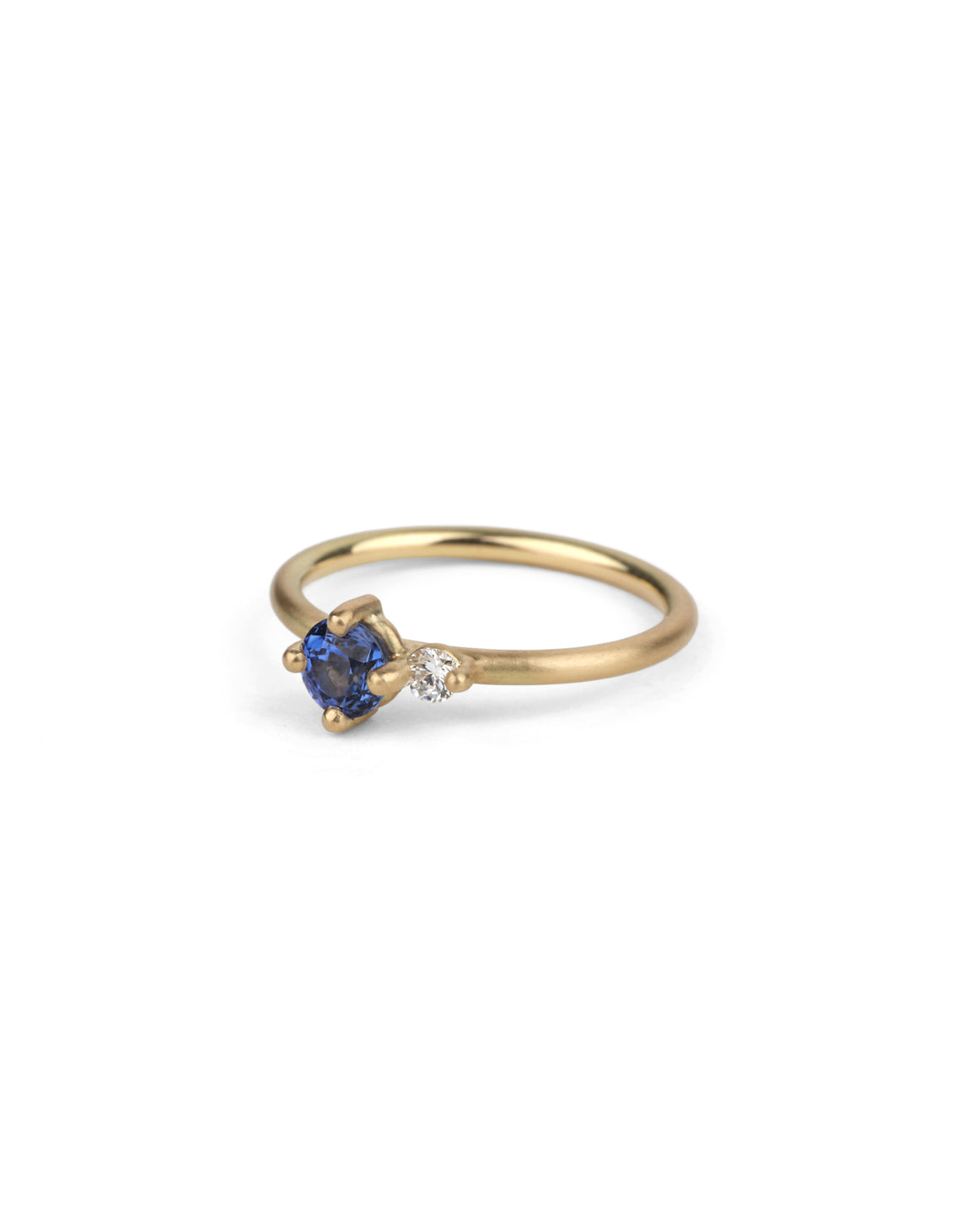 Round vivid blue sapphire ring with a round white diamond. 18ct yellow gold, satin finish.