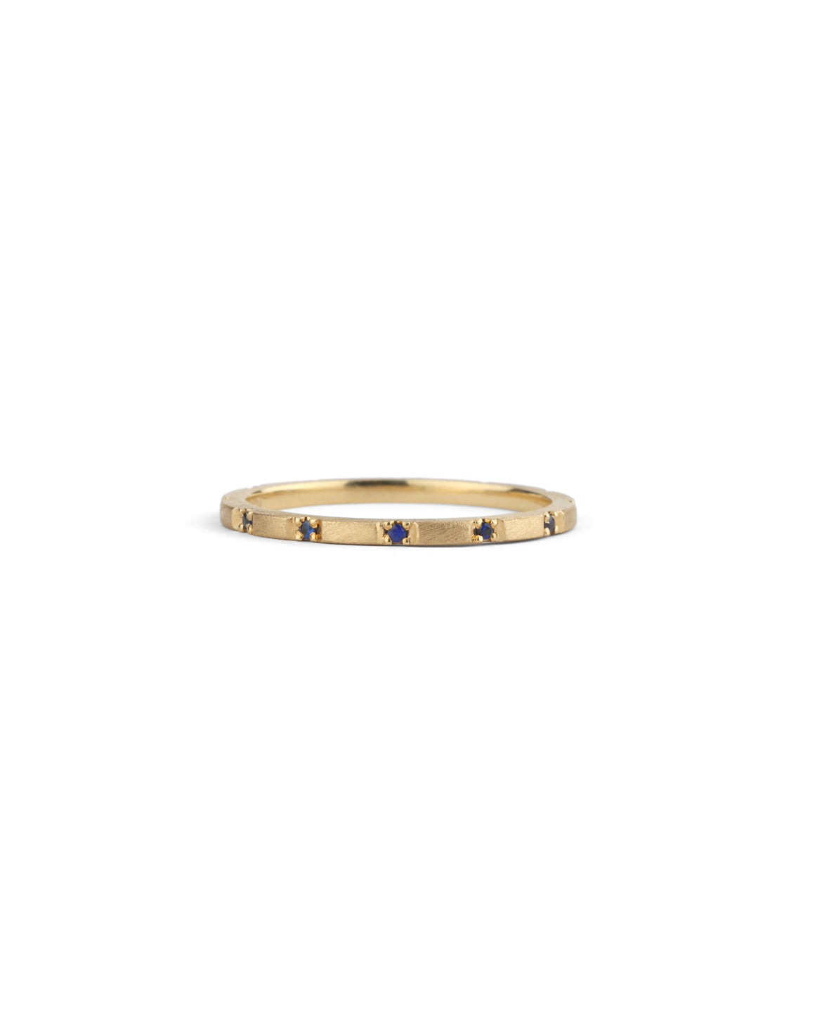 Fine gold band with set with small dark blue sapphires. 18ct yellow gold textured finish.