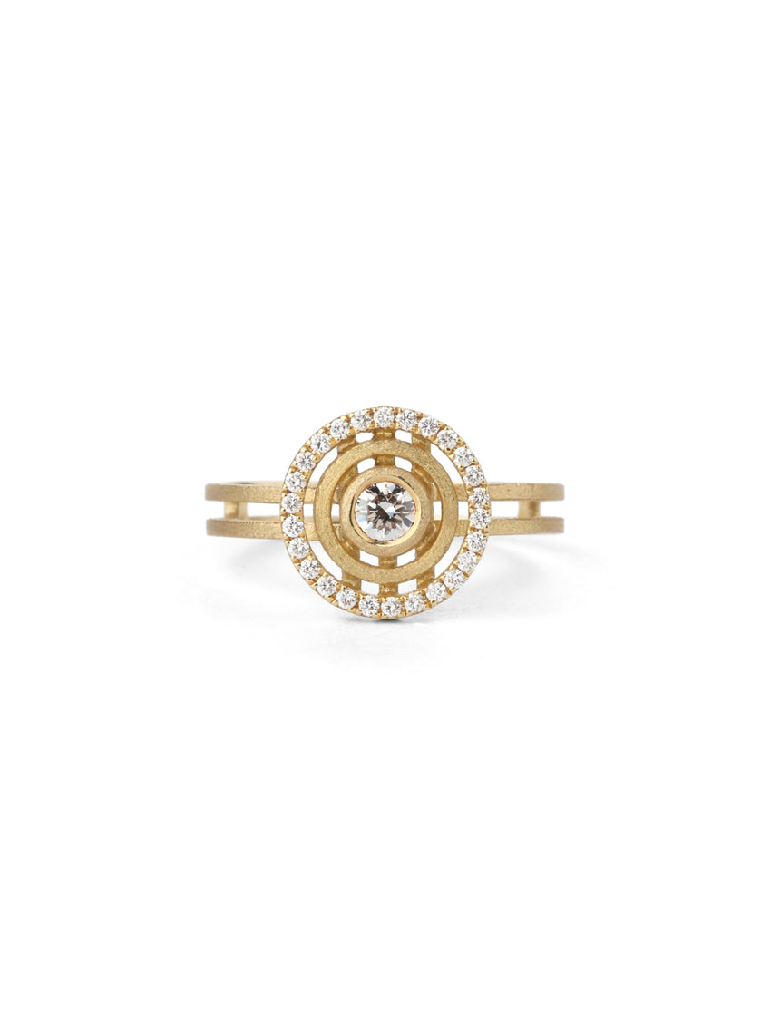 Geometric ring with concentric circular detail, diamond halo and central diamond. 18ct yellow gold textured finish.