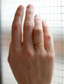 Solitaire ring with round white diamond, four claw setting. 18ct yellow gold, satin finish. Worn on hand.