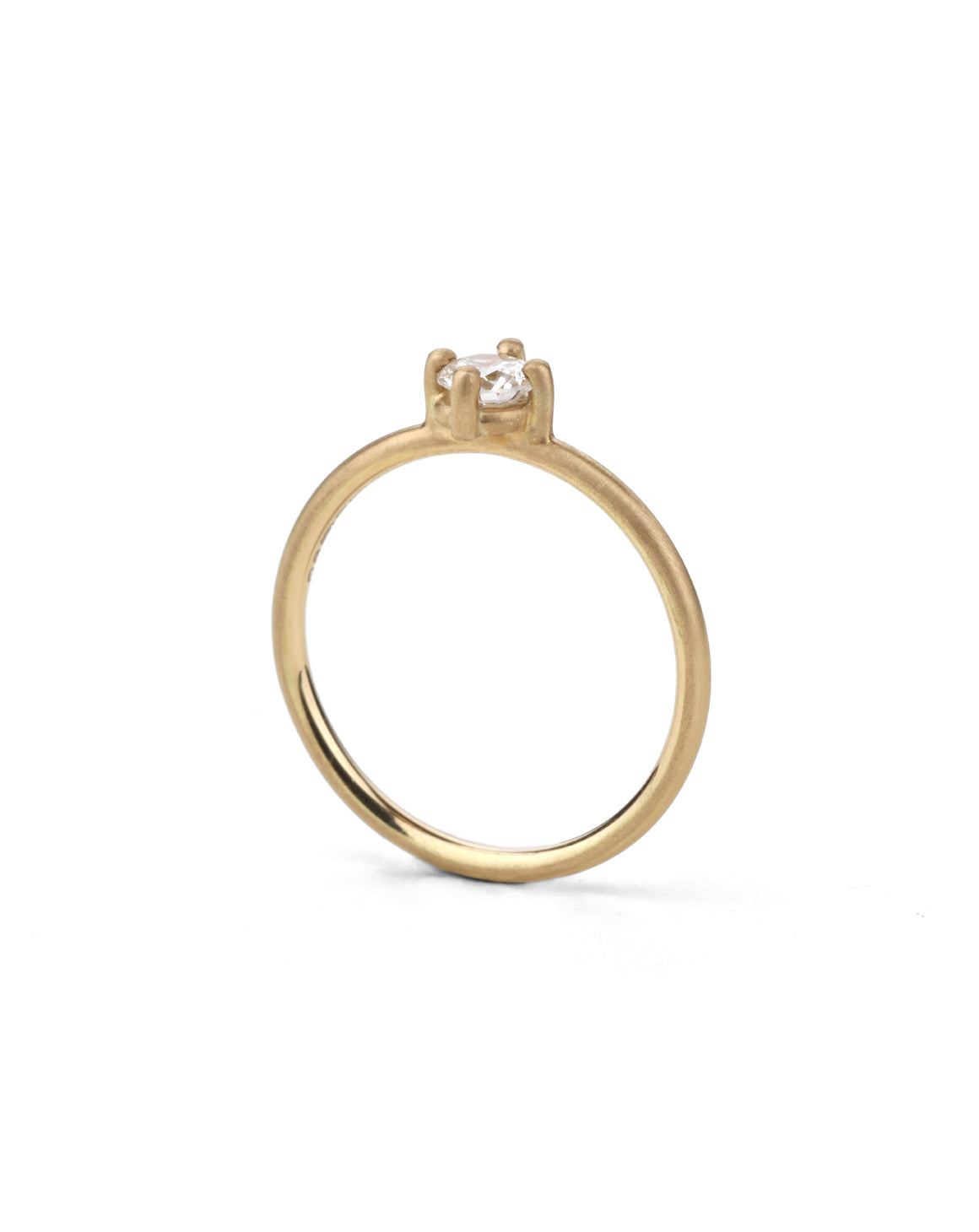 Solitaire ring with round white diamond, four claw setting. 18ct yellow gold, satin finish. Side view.
