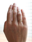 Solitaire ring with round white diamond and double band. 18ct yellow gold, satin finish. On the hand.