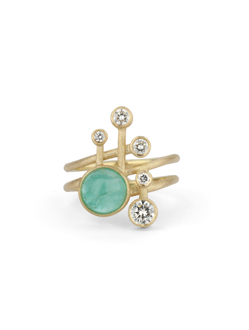 Asymmetric statement ring with round emerald and five white diamonds.