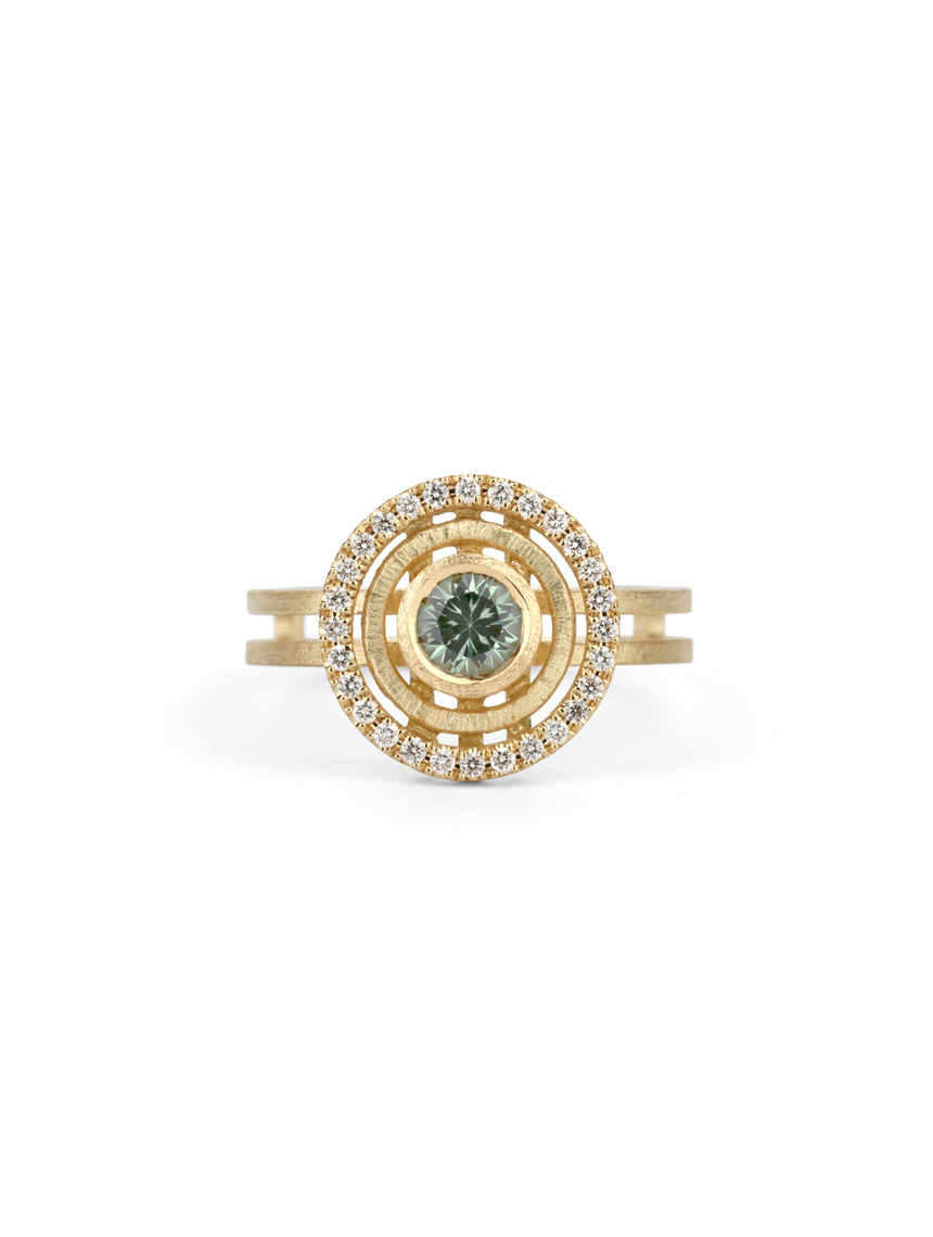 Green sapphire ring with circular detail and white diamond outer halo.  18ct yellow gold, textured finish.