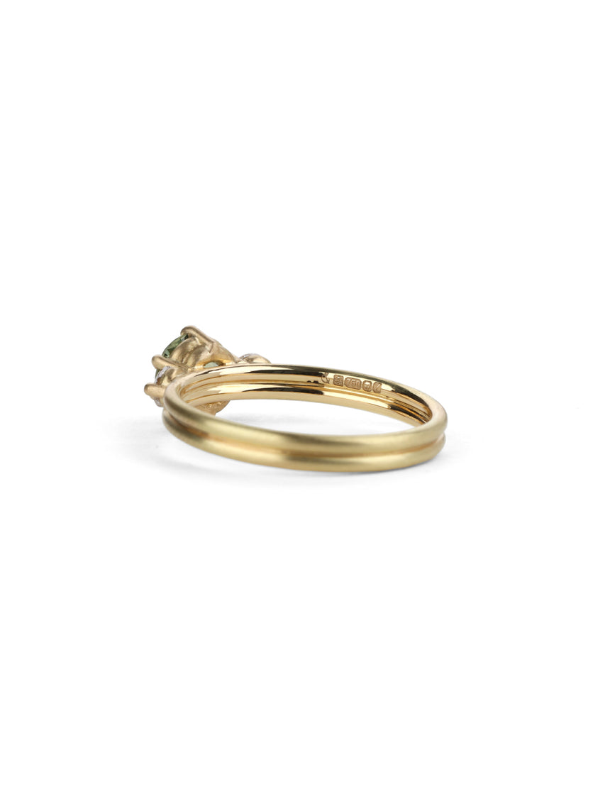 Three stone ring with green sapphire and white diamonds. Joined double band, 18ct yellow gold satin finish. Side view.