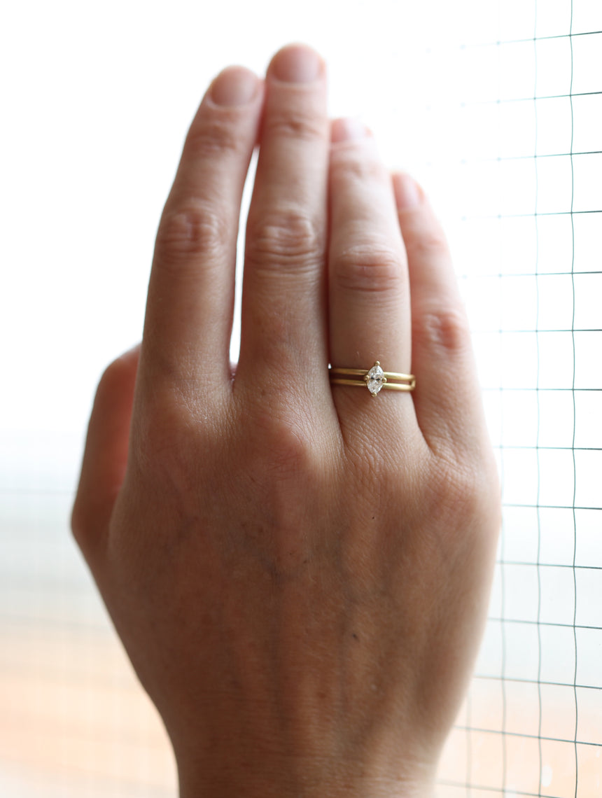 Marquise white diamond solitaire ring with double band. 18ct yellow gold, satin finish. On hand.