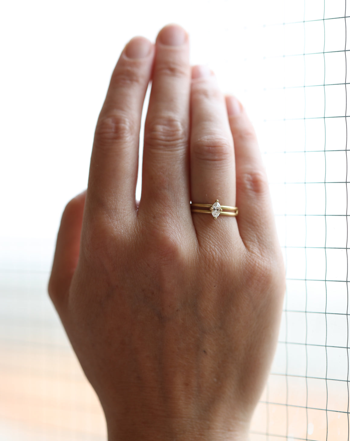 Marquise white diamond solitaire ring with double band. 18ct yellow gold, satin finish. On hand.