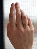 Rectangle green sapphire ring with geometric setting and double band. 18ct yellow gold, textured finish. On hand.