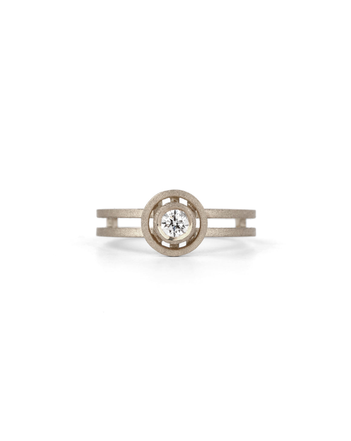 Geometric ring with circular detail and central diamond and double band. 18ct white gold, textured finish.