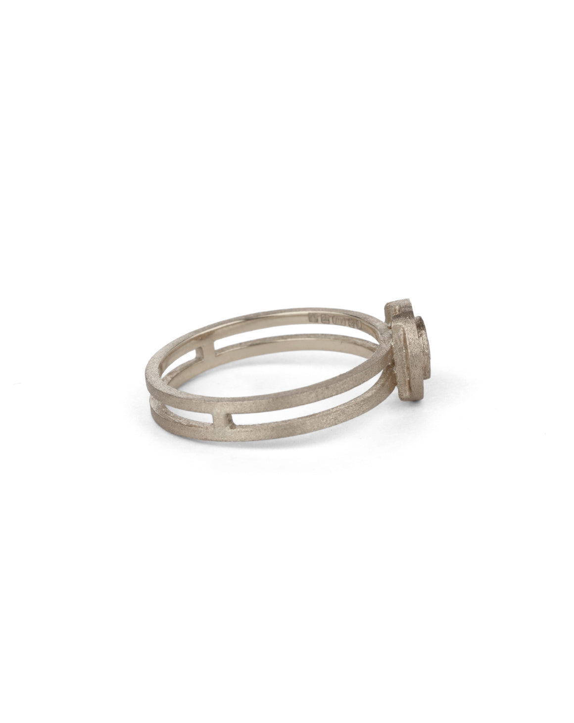 Geometric ring with circular detail and central diamond and double band. 18ct white gold, textured finish. Side view.