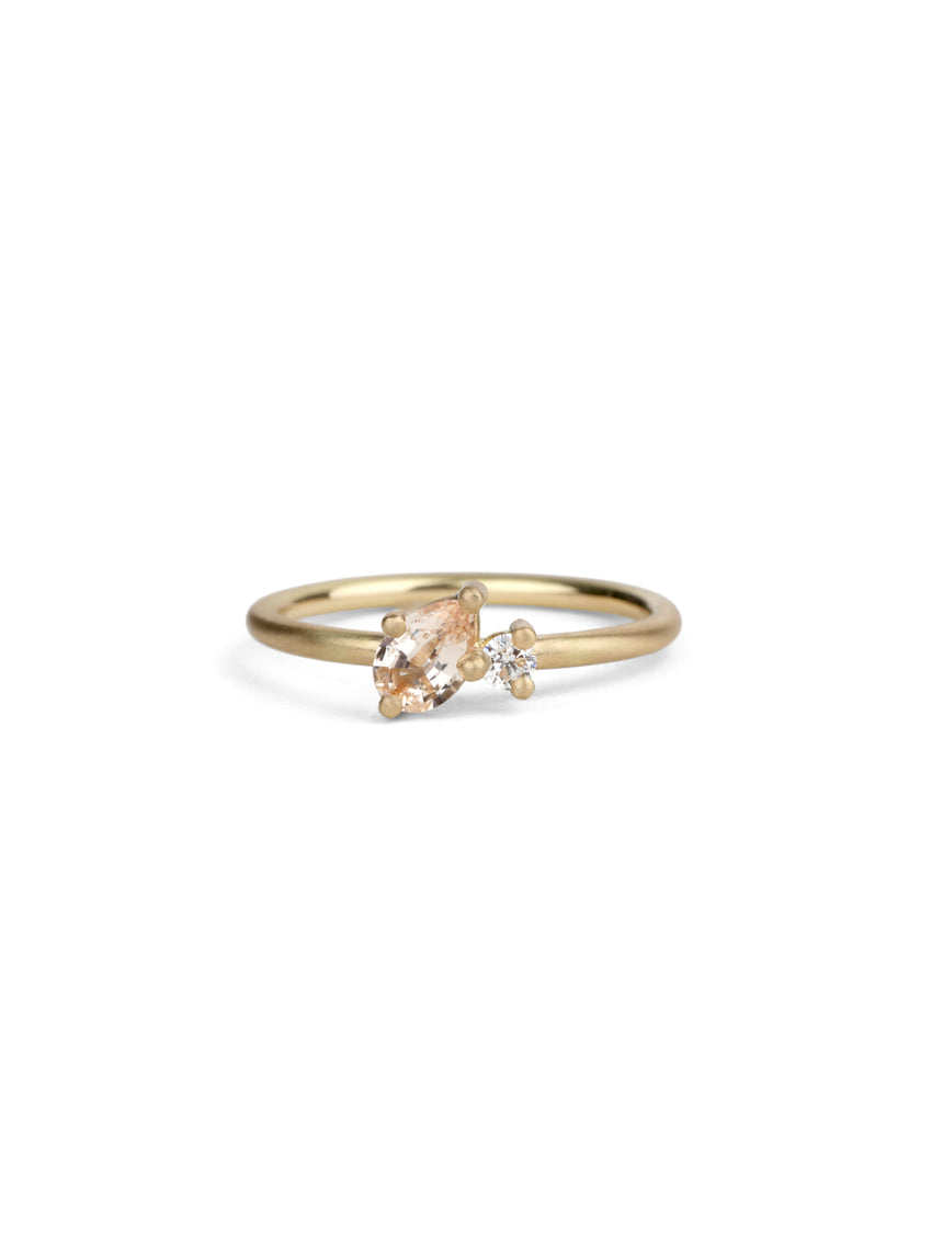 Two stone ring with teardrop shape peach sapphire and round white diamond. 18ct yellow gold, satin finish.