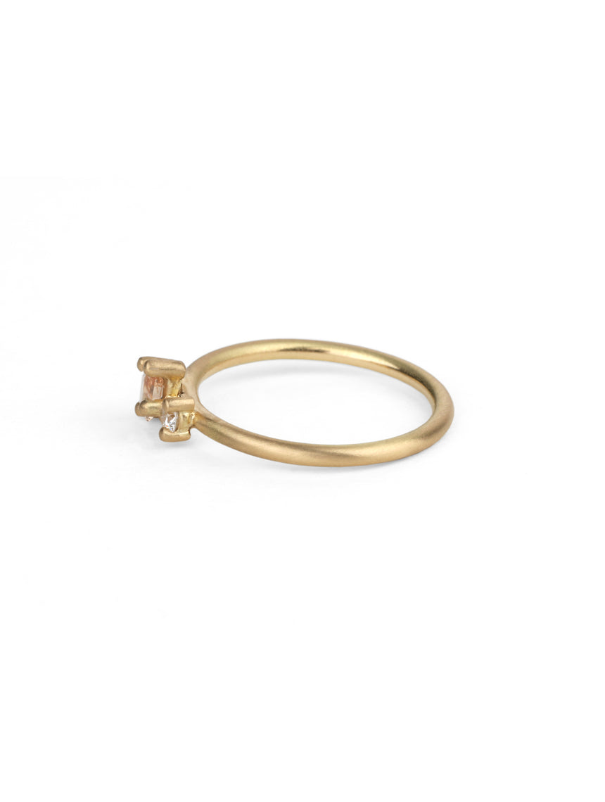 Two stone ring with teardrop shape peach sapphire and round white diamond. 18ct yellow gold, satin finish. Side view.