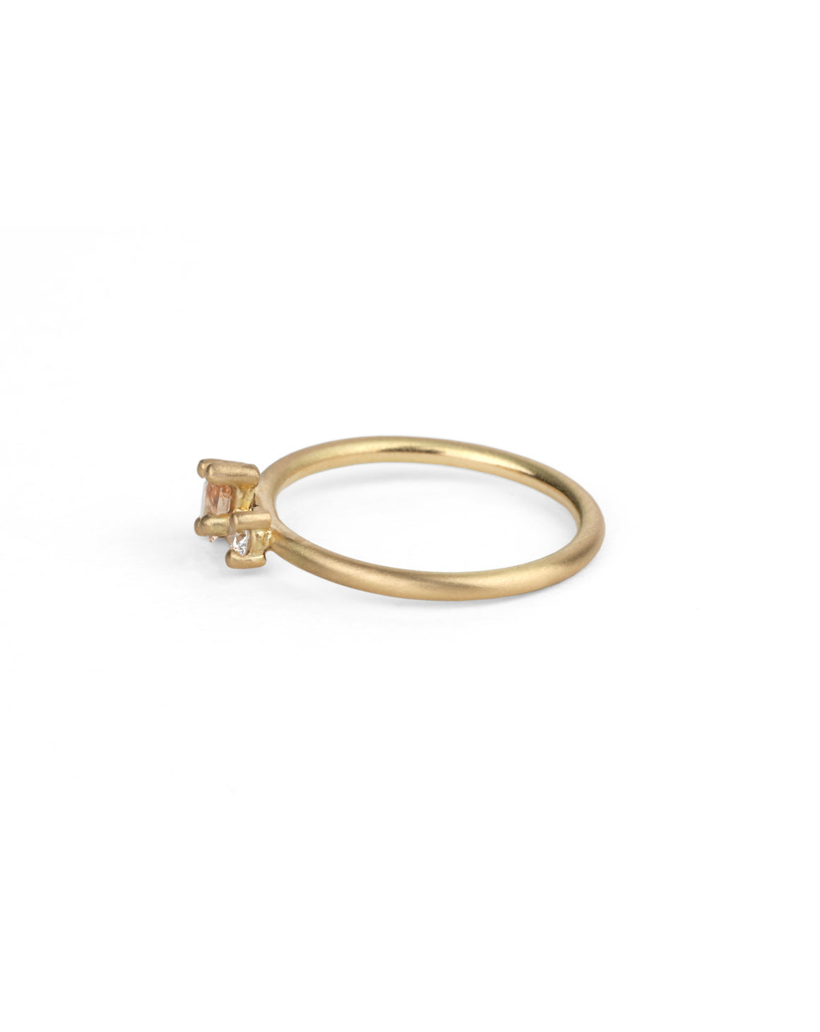 Two stone ring with teardrop shape peach sapphire and round white diamond. 18ct yellow gold, satin finish. Side view.