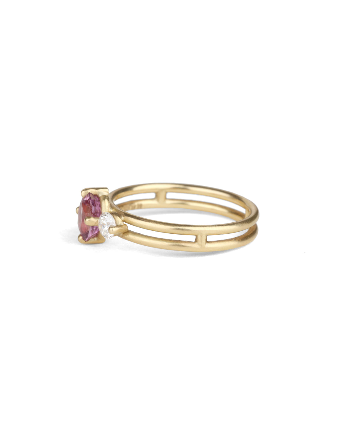 Three stone ring with a pink oval sapphire and two white diamonds. 18ct yellow gold, satin finish. Side view.