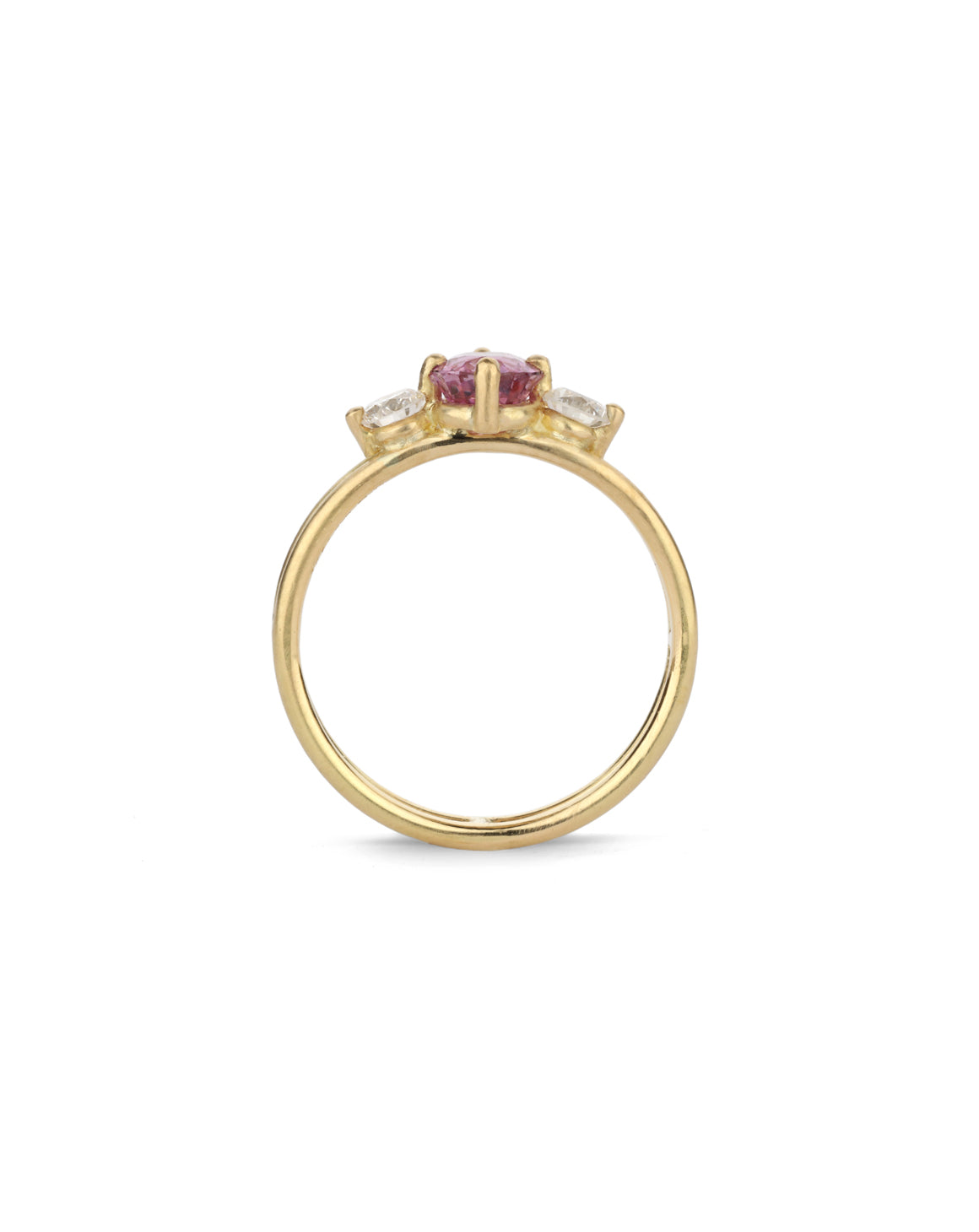 Three stone ring with a pink oval sapphire and two white diamonds. 18ct yellow gold, satin finish. Side view.