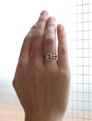 Solitaire ring with oval teal sapphire and double band. 18ct yellow gold, satin finish. On hand.