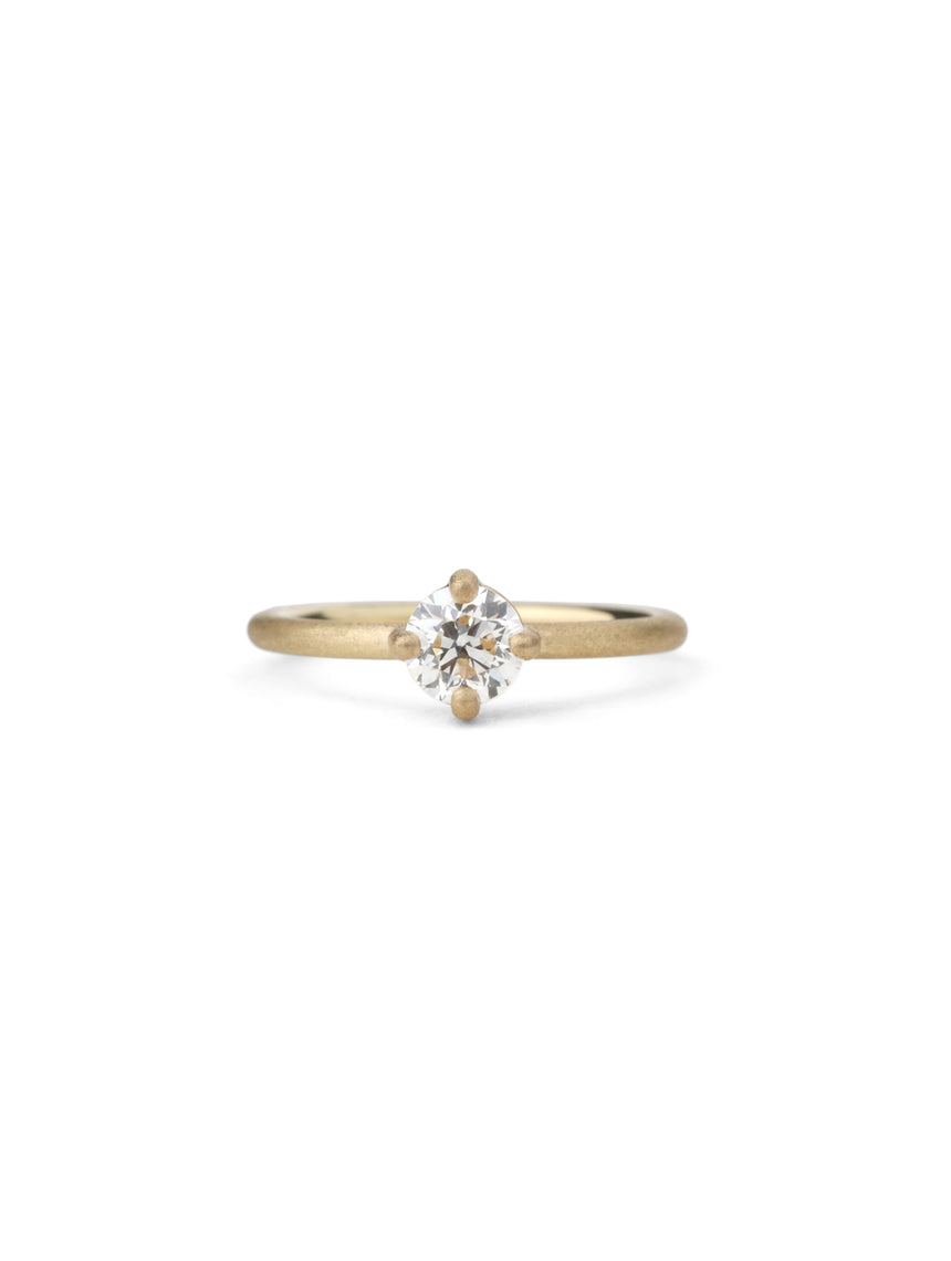 Solitaire ring with round white diamond, four claw setting. 18ct yellow gold, textured finish.