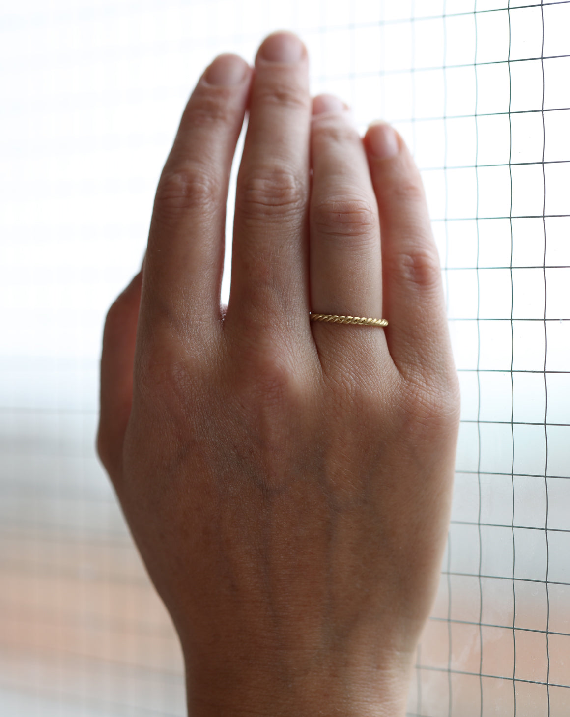 Rope style ring in 18ct yellow gold, satin finish. On hand.