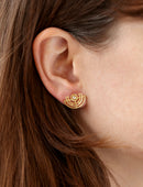 Geometric earrings with semicircular detail and central white diamond. 18ct yellow gold, textured finish. On ear.