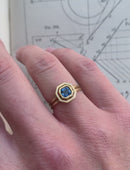 Octagon blue sapphire ring with surround detail and double band. 18ct yellow gold with satin finish. On hand.