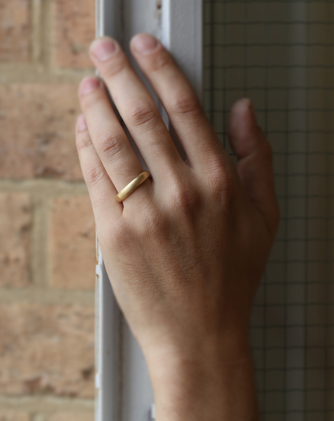 Rounded wedding band. 18ct yellow gold, satin finish. On hand.