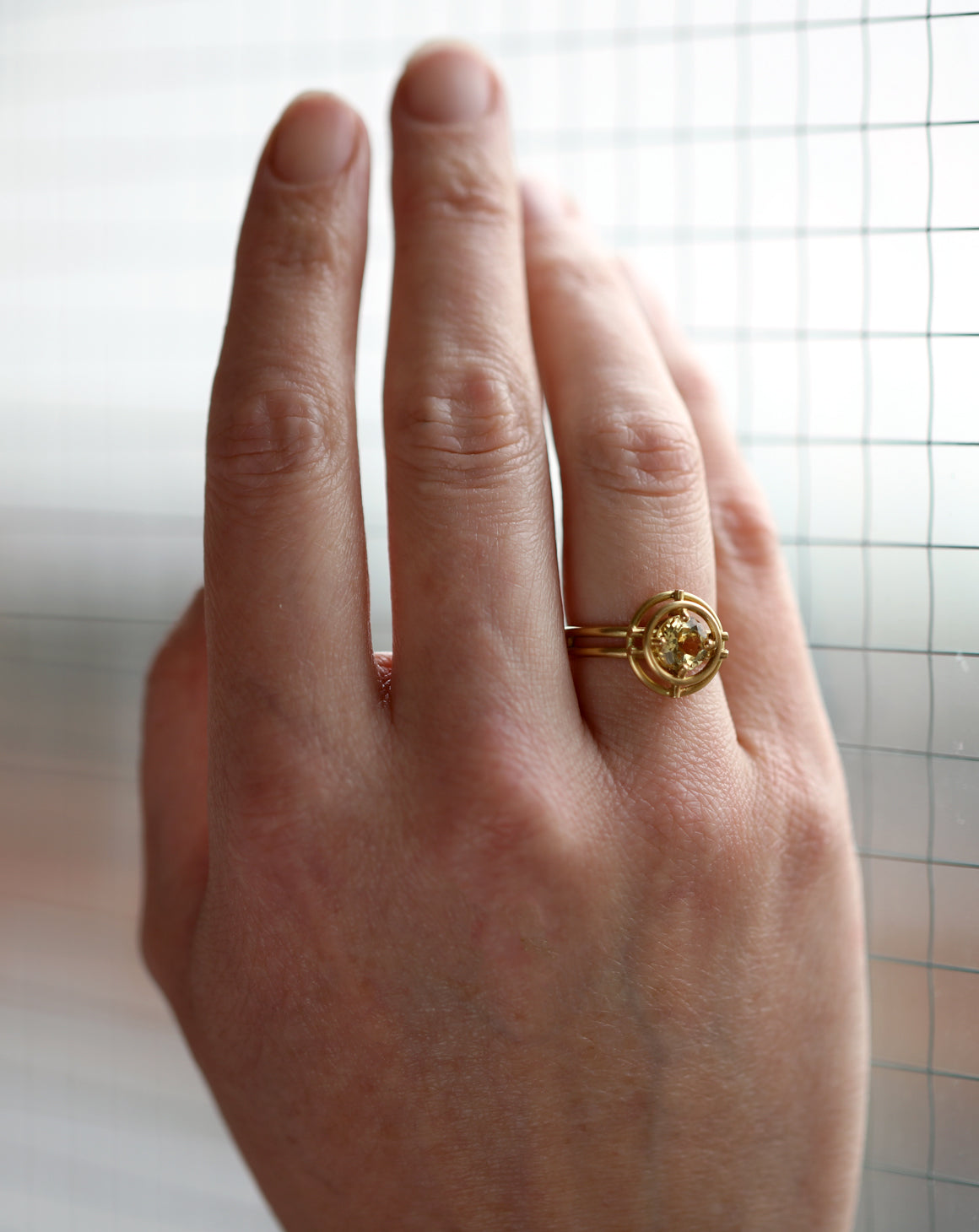 Geometric Ring with two concentric circles surrounding a yellow beryl. 18ct yellow gold, satin finish. On hand.